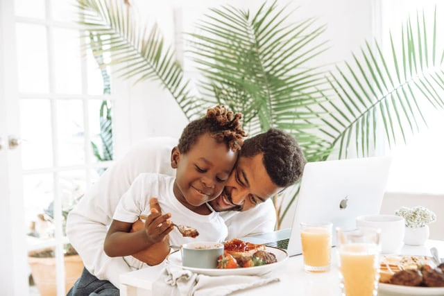 A man and his daughter eating breakfast at home.